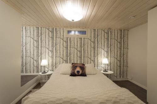a dog laying on a bed in a bedroom at Villa Nietos in Rovaniemi
