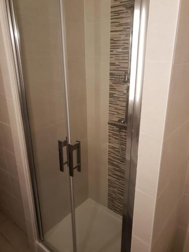 une douche avec une porte vitrée dans une salle de bain dans l'établissement Beautiful Old property in Bordeaux Center, à Bordeaux