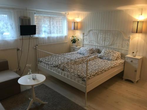 1 dormitorio con cama, mesa y TV en Room with pentry, separate entrance, no cardpayment en Gränna
