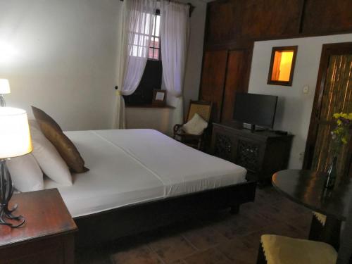 a bedroom with a bed and a table and a television at Giron Chill Out Hotel Boutique in Girón