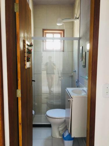 a bathroom with a toilet and a shower and a sink at Casas Aconchegantes Temporada in Cabo Frio