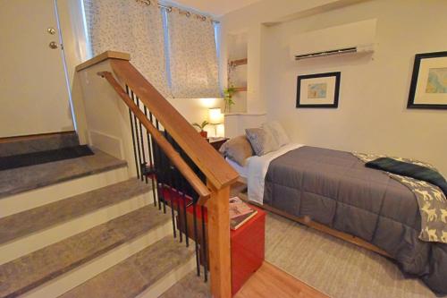 a bedroom with a bed and a staircase with a stair case at Amazing Location studio parking in Boston