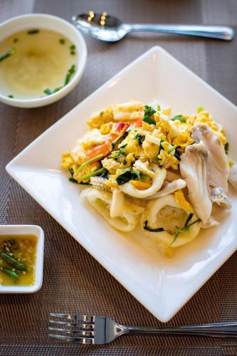 een wit bord met eten op een tafel bij Chaanburi Boutique Resort in Chanthaburi