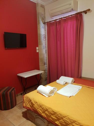 a room with a bed with a tv and a table at Aktaion Hotel in Monemvasia