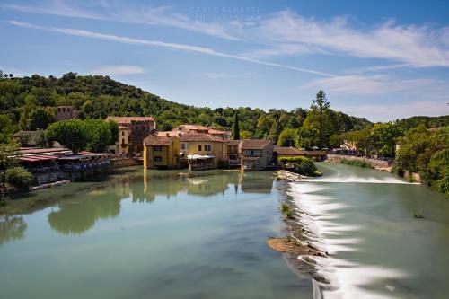 widok na rzekę z domami i budynkami w obiekcie Le Finestre Su Borghetto w mieście Valeggio sul Mincio