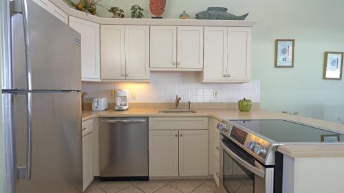 a kitchen with white cabinets and a stainless steel refrigerator at Sea Crest in Amagansett