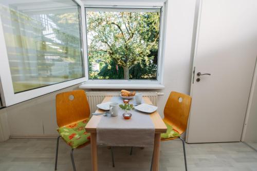 a table and chairs in a room with a window at flat2let Apartment 1 in Frankfurt/Main