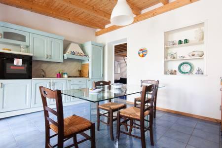 a kitchen with a glass table and chairs in it at Le Case di VirGin 1 in Castellammare del Golfo