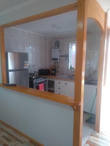 a kitchen with a stove and a refrigerator at Departamento Familiar in Coquimbo