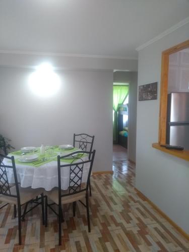 a dining room with a table with chairs and a refrigerator at Departamento Familiar in Coquimbo