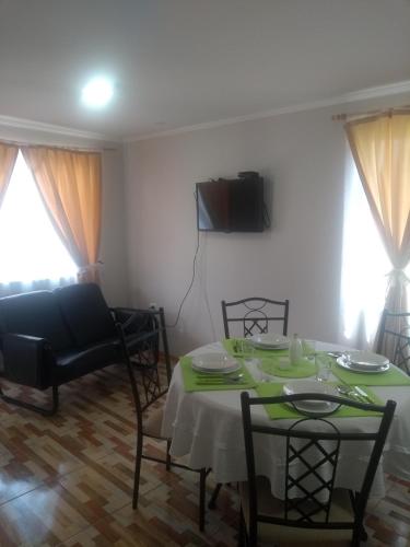 a living room with a table and chairs and a couch at Departamento Familiar in Coquimbo