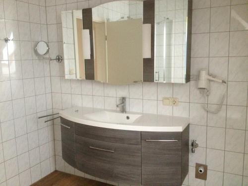een badkamer met een wastafel en een spiegel bij Seestern 4 in Greetsiel