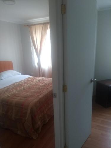 a bedroom with a bed and a window at Departamento Familiar in Coquimbo