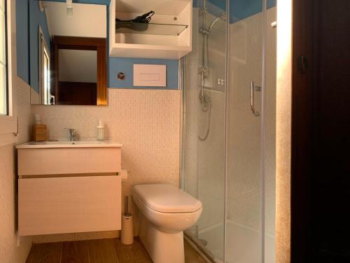 uma casa de banho com um WC e uma cabina de duche em vidro. em Villa Arcipelago em Cefalù