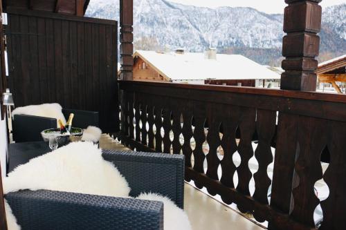 Hardi's Hotel في انزل: شرفة مع طاولة وكراسي مع جبال مغطاة بالثلج
