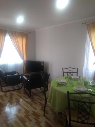 a dining room with a green table and chairs at Departamento Familiar in Coquimbo
