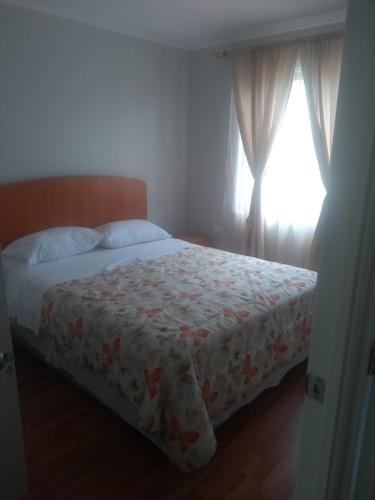 a bedroom with a bed and a window at Departamento Familiar in Coquimbo