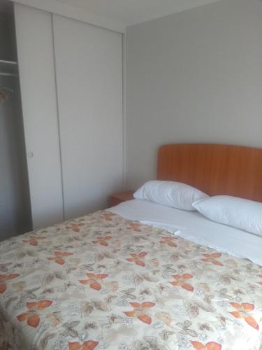 a bedroom with two beds with a floral bedspread at Departamento Familiar in Coquimbo