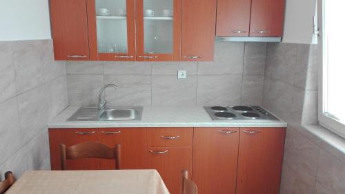 a kitchen with brown cabinets and a sink and a table at Apartment for Holidays in Pula in Pula