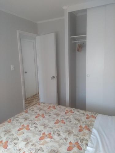 a bedroom with a bed with a floral bedspread at Departamento Familiar in Coquimbo