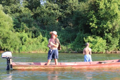 two men standing in a boat on a river at Holiday homes Piralo in Kostajnica