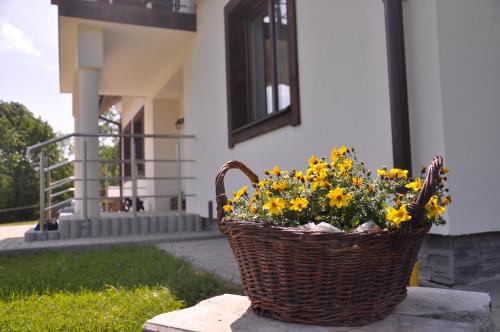 a basket full of yellow flowers sitting on a curb at Maniówka - pokoje i domki w Bieszczadach in Maniów