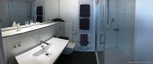 a bathroom with a sink and a shower and a toilet at Meermomente in Helgoland