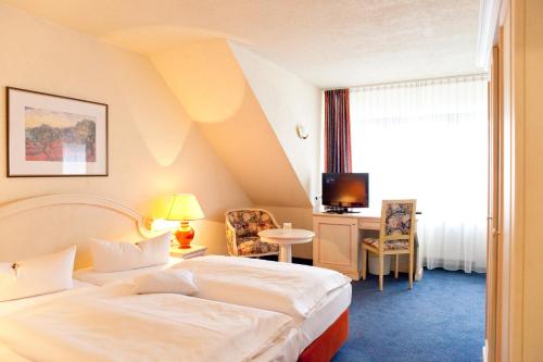 a hotel room with a bed and a tv at Hotel Weißes Roß in Marienberg