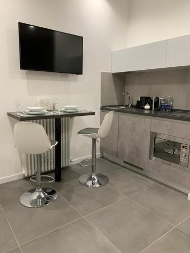 a kitchen with a table and two chairs and a television at ApartHotel Bossi in Milan