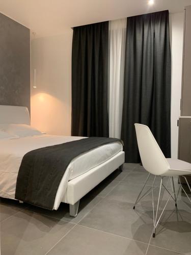a bedroom with a bed and a white chair at ApartHotel Bossi in Milan