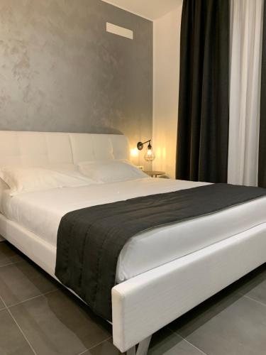 a white bed with a black blanket on it at ApartHotel Bossi in Milan