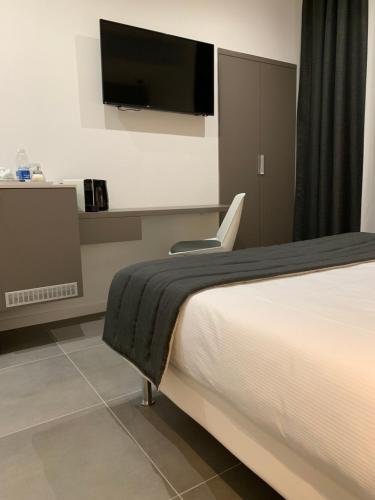 a bedroom with a bed and a flat screen tv at ApartHotel Bossi in Milan