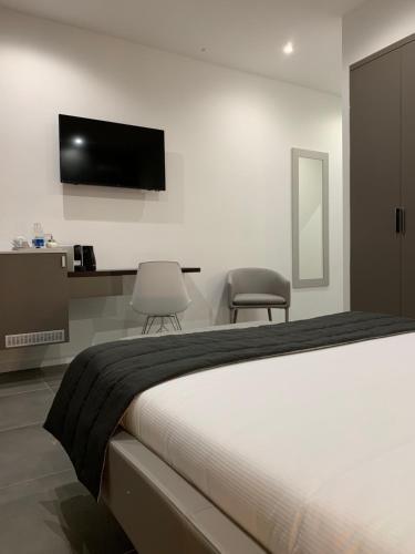 a bedroom with a bed and a tv on the wall at ApartHotel Bossi in Milan