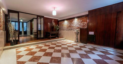 a lobby with a checkered floor and a brick wall at Cà Mocenigo Nobile in Venice