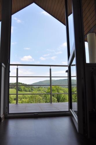 an open door to a balcony with a view at Maniówka - pokoje i domki w Bieszczadach in Maniów