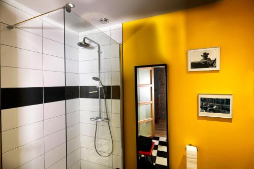 baño con ducha y pared amarilla en Maison des Orfèvres en Arbois