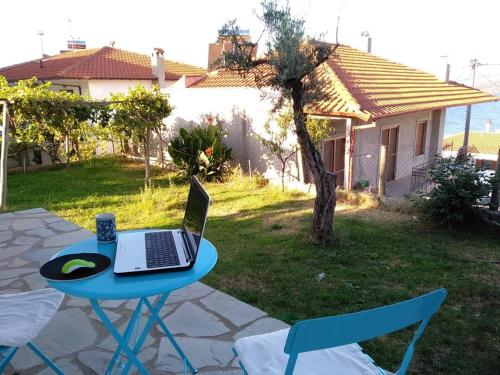 a blue table with a laptop on it in a yard at Dora's House comfortable apartment with a yard and view in Pyrgadikia