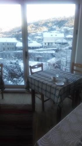 a table in a room with a view of a snow covered field at Hotel Arhontiko Vourloka in Pramanta