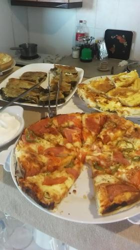 a table with three slices of pizza on plates at Hotel Arhontiko Vourloka in Pramanta