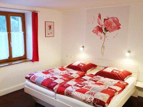 a bedroom with a bed with a red and white quilt at Le Chamois in Sondernach