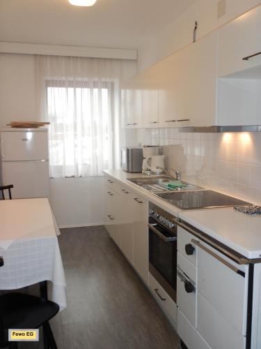 a white kitchen with a sink and a stove at Landhaus Kügler-Eppich, KuEp KG in Proleb