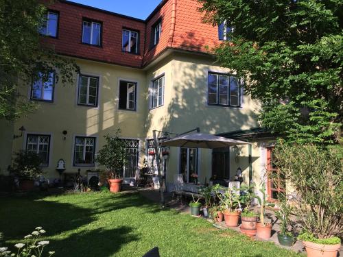 a house with a yard with potted plants in front of it at Schön wohnen nähe Schönbrunn in Vienna