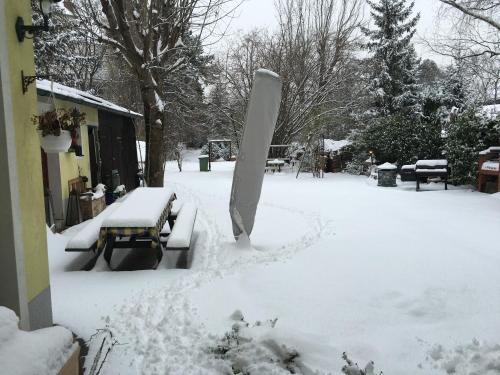 a snow covered yard with benches and a snowboard at Schön wohnen nähe Schönbrunn in Vienna