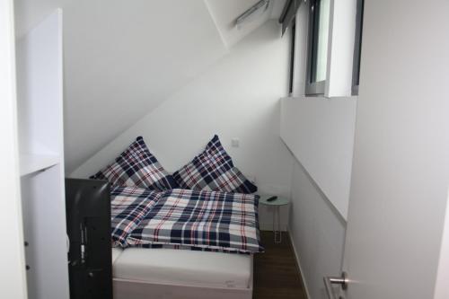 una habitación con dos almohadas a cuadros sentadas en un banco en Nummer Zwo, en Helgoland