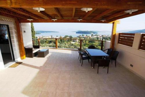 a patio with a table and chairs on a balcony at Princes ' Islands Luxury Residences in Nydri