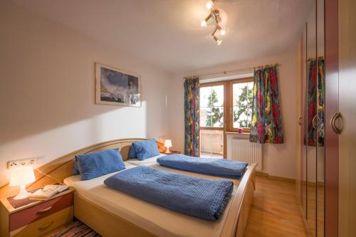 1 Schlafzimmer mit 2 Betten und einem Fenster in der Unterkunft Appartement Steinbock in Sankt Johann in Tirol