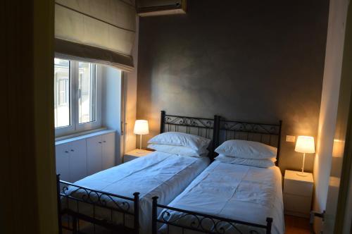 una camera con due letti con lenzuola bianche e una finestra di Una finestra su Castel Sant'Angelo a Roma