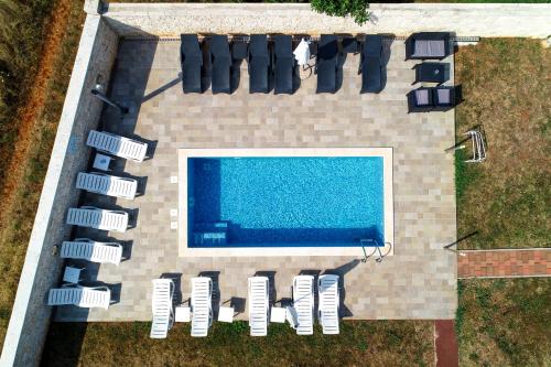 una vista aérea de una piscina con sillas alrededor en Apartments & Rooms Villa Adamović, en Umag