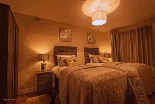a bedroom with two beds and a lamp on a table at Birmingham Apartments Yardley B, BHX, NEC & City Centre in Birmingham