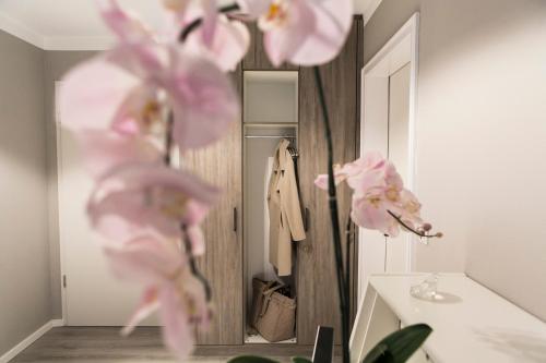 uma casa de banho com flores cor-de-rosa em frente a um espelho em Quartier 23 em Nordhorn